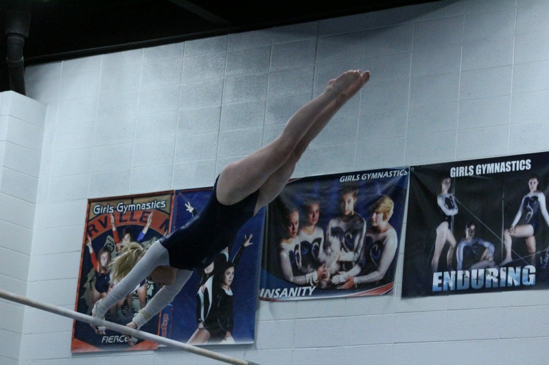 Junior Grace Ryan performs on the uneven bars