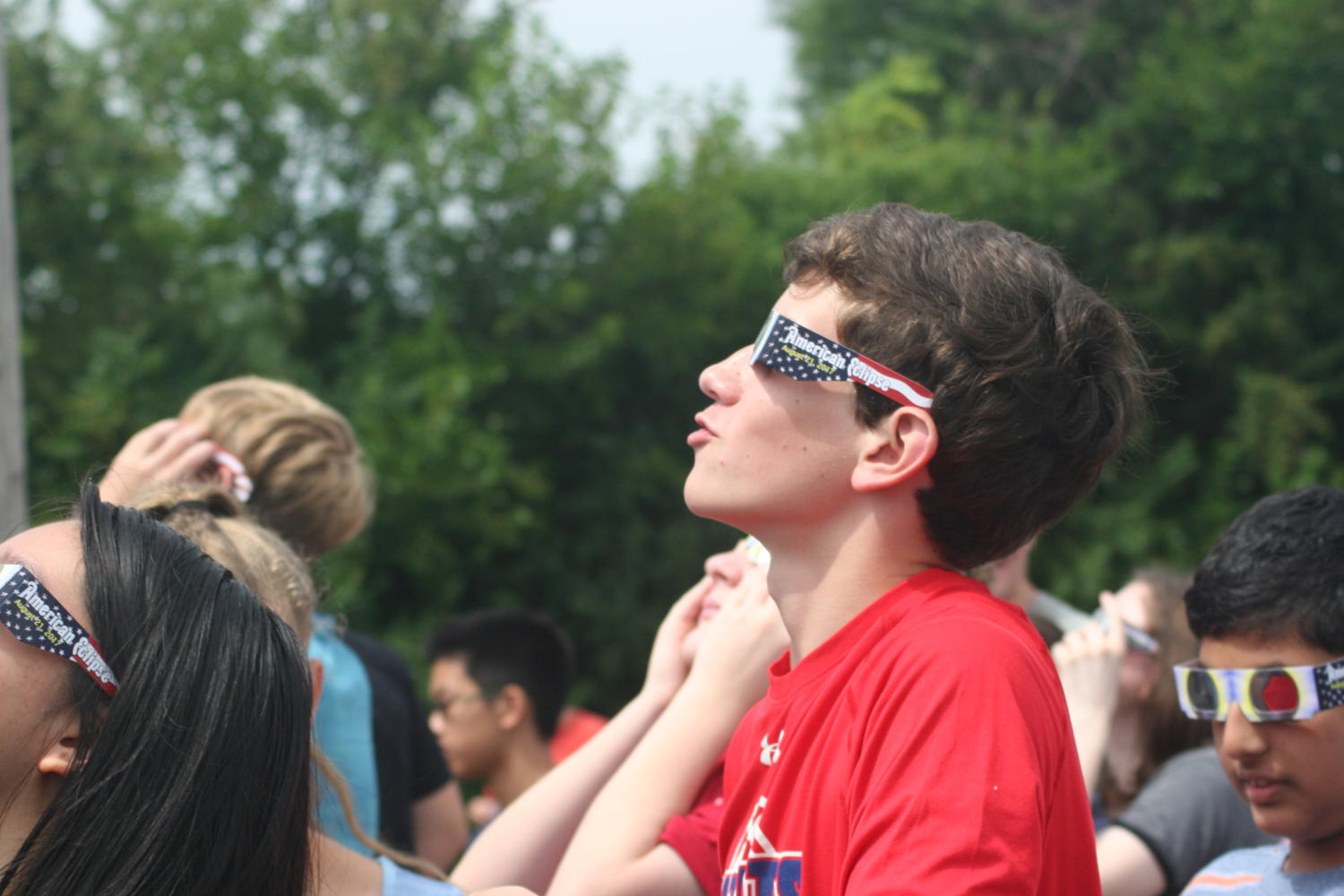 A Naperville North student gazes up at the partial eclipse during the outdoor viewing assembly. The eclipse reached its peak in Naperville at approximately 1:19 p.m. just after the student body gathered in the bleachers.