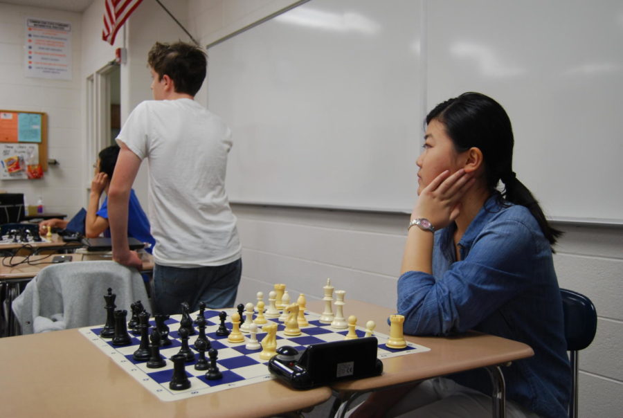 Marissa Li listens to her coach’s instructions at an NNHS chess team practice.