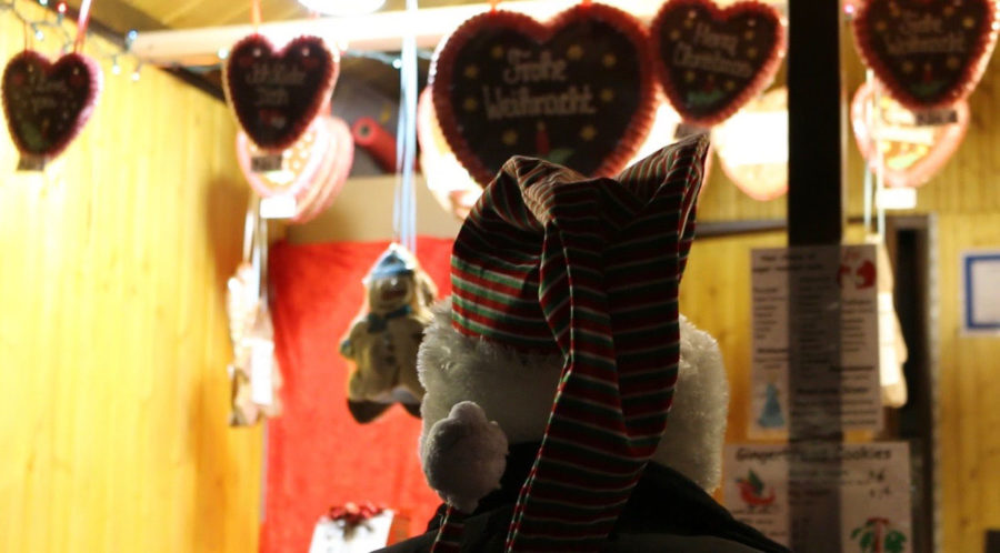 A person looks through the window of a nearby vendor at Christkindlmarket. The market first opened in Naperville last year, and people from near and far have flocked to it ever since.