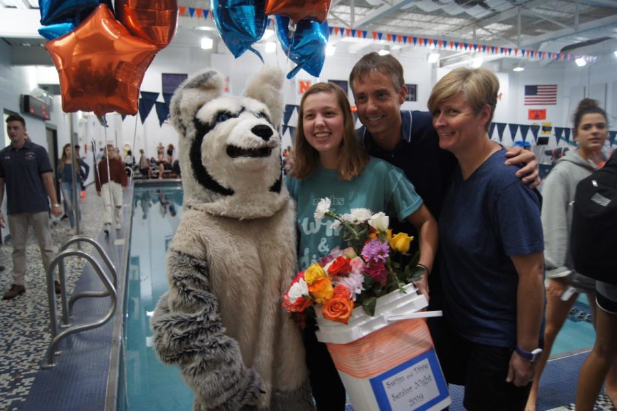 Senior Libby Spreitzer poses for a photo with Buster and her parents.
