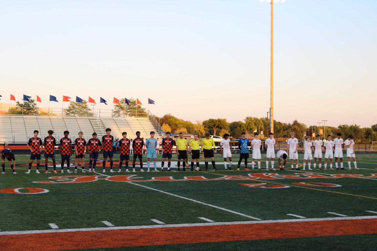 Naperville North High School and Naperville Central High School's boys soccer teams line up for the announcement of the starting players.