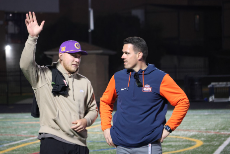 Minnesota Vikings player and former Naperville North High School student Bo Richter speaks with NNHS Athletic Director Jon Pereiro during a Huskie varsity football game.