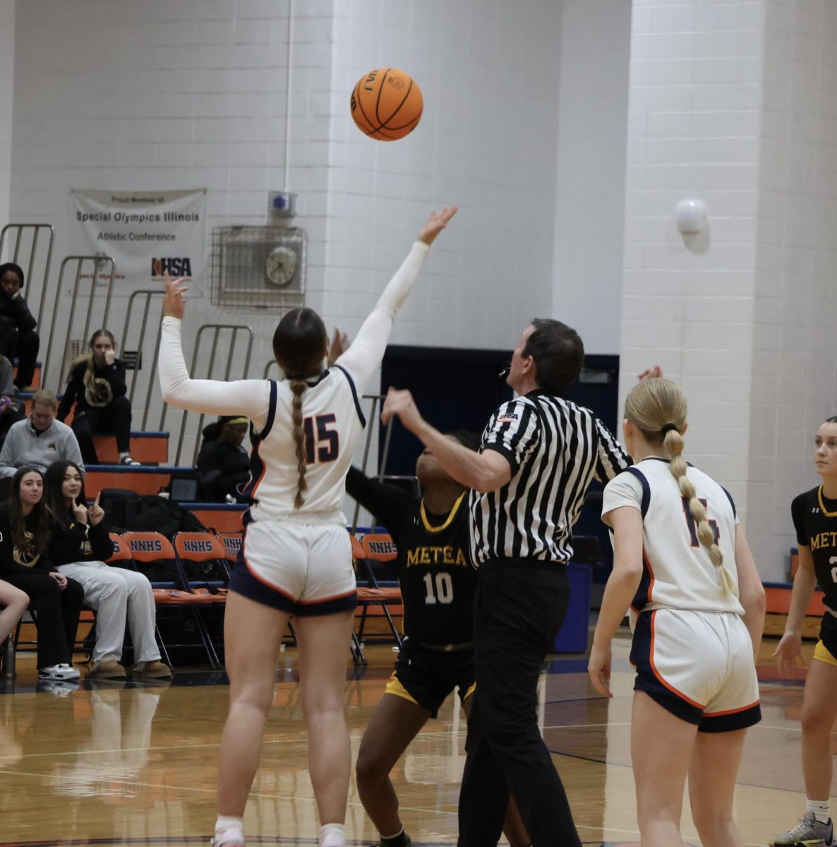 Ema Gilvydis (15) reaches for the jump ball to start the game.