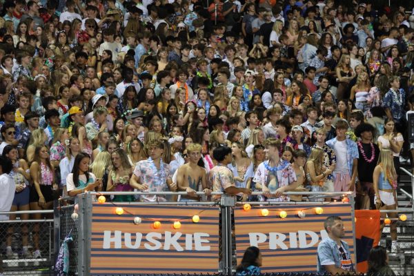 Dawg Pound leaders stand at the front of Naperville North's cheering section during a home football game.