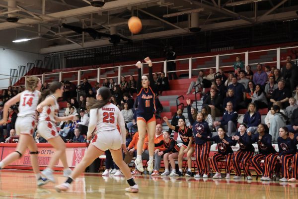 Sam Kelly (11) takes a 3-point shot with intense focus.