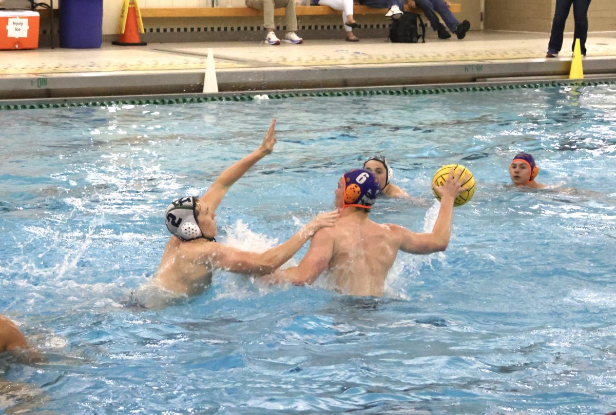 Mason Hofmann (6) rises up past Trevian Caden Adrianopoli (2) to make a pass.