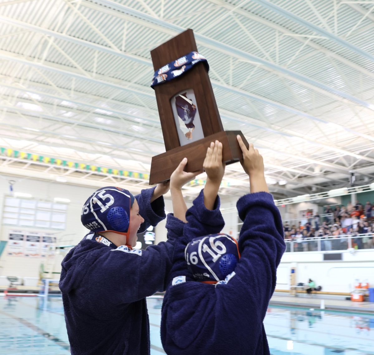 Captains Payton Schrier (15) and Ria Vaid (16) hoist up the third-place state trophy.