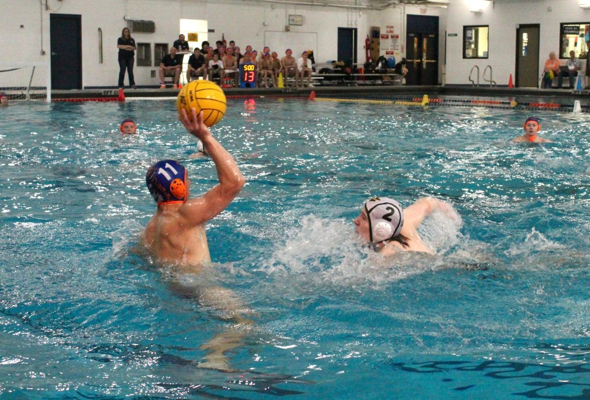 Caden Tsao (11) looks for a pass as he moves away from a Warrior defender.
