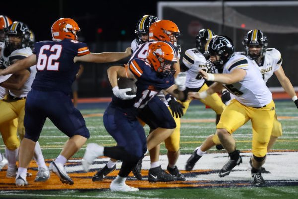 Senior William Eloe (17) runs the ball past the Metea Valley defense.